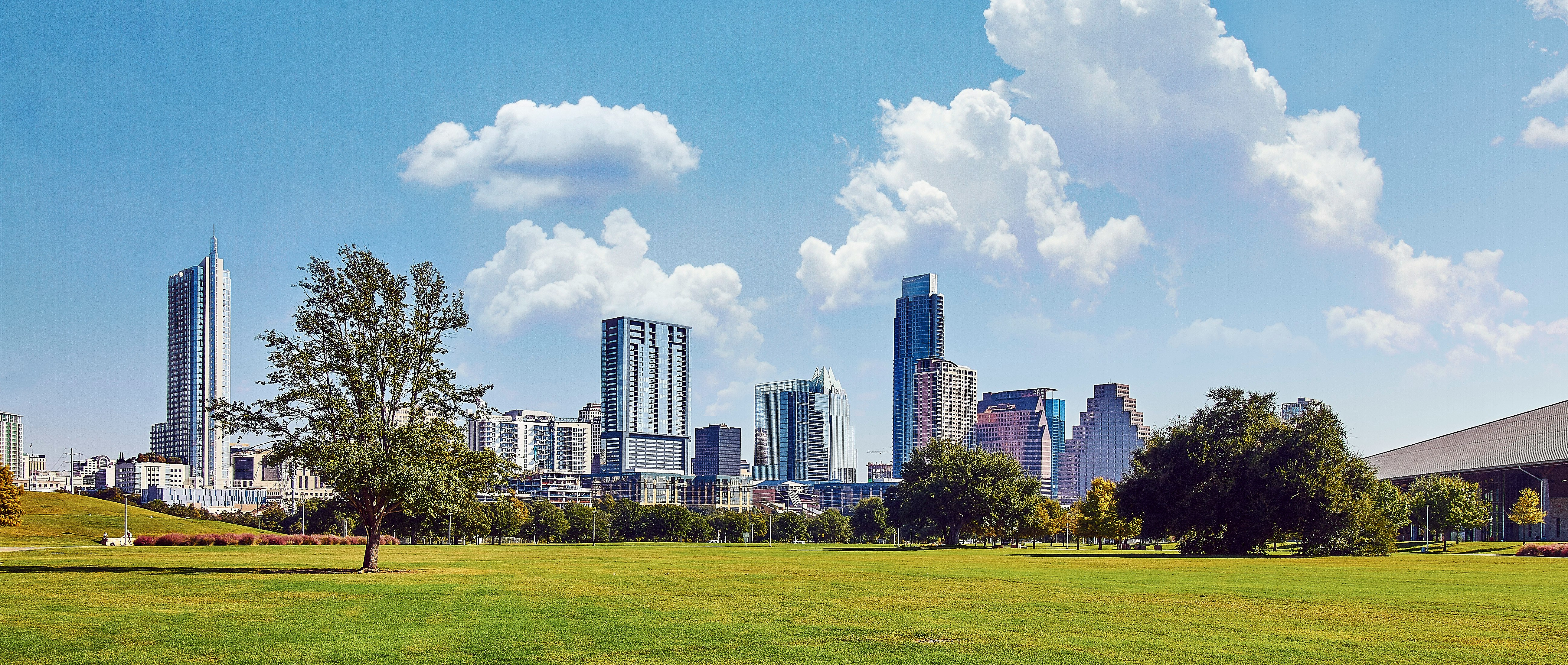 green grass field in front of high-rise buildings during daytime